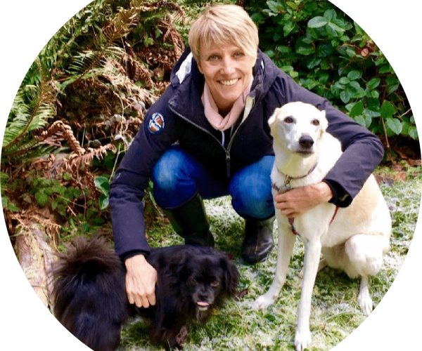 Sarah, a mentor at The Academy for Dog Trainers, poses with two dogs